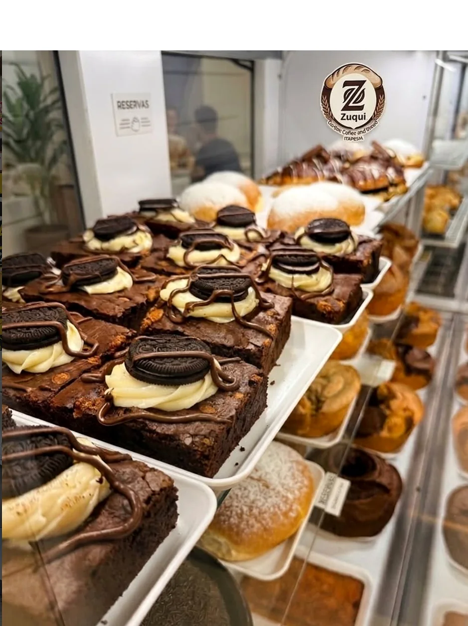 Vitrine real do Zuqui com brownies, sonhos e produtos de padaria